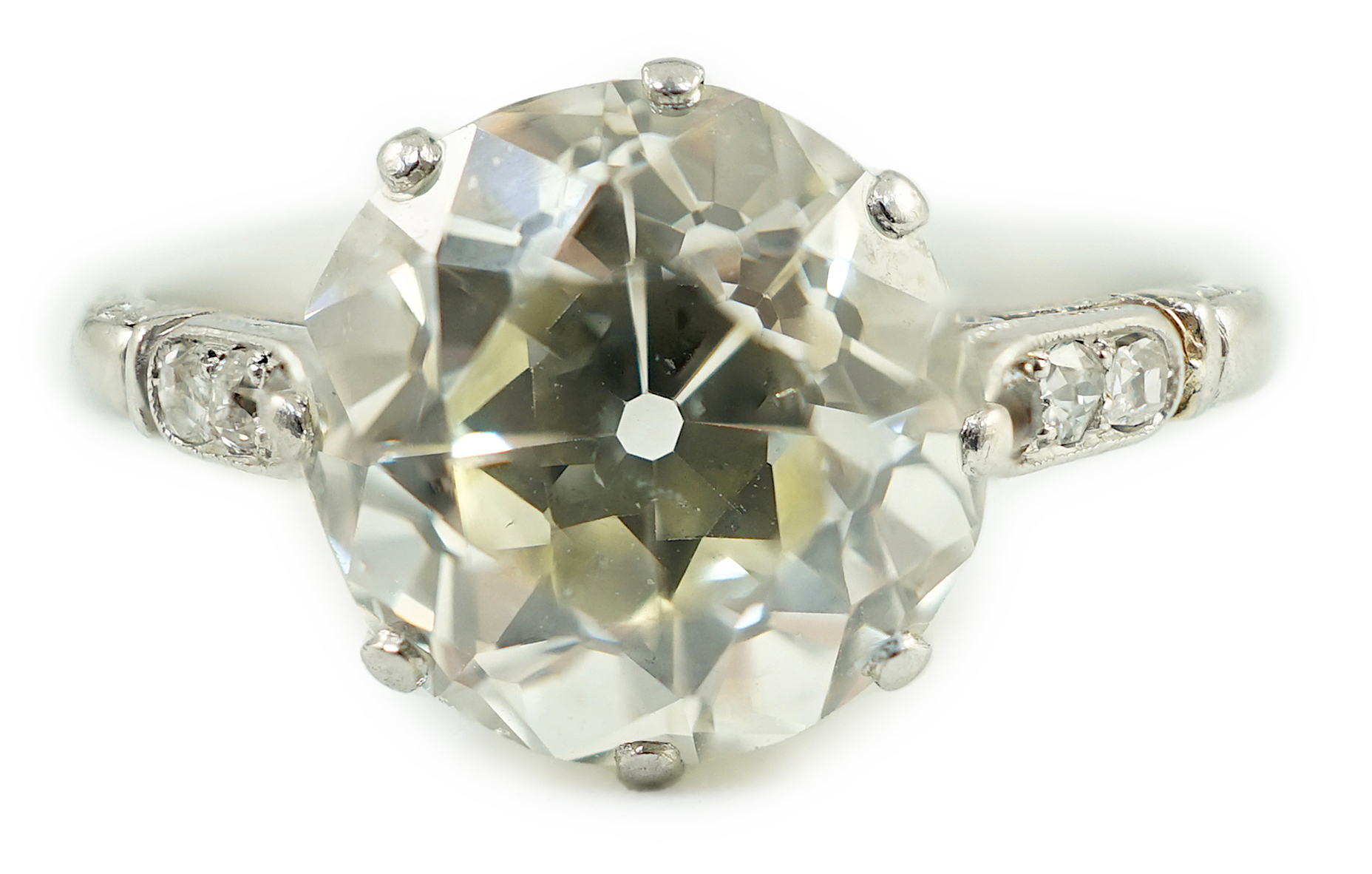 A mid 20th century platinum and single stone diamond ring, with six stone diamond chip set shoulders